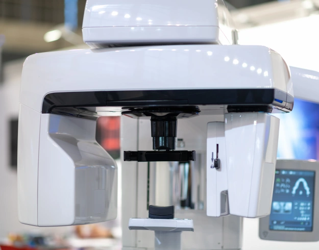 Dental laboratory analyzer machine with white exterior and black components in clinical setting.