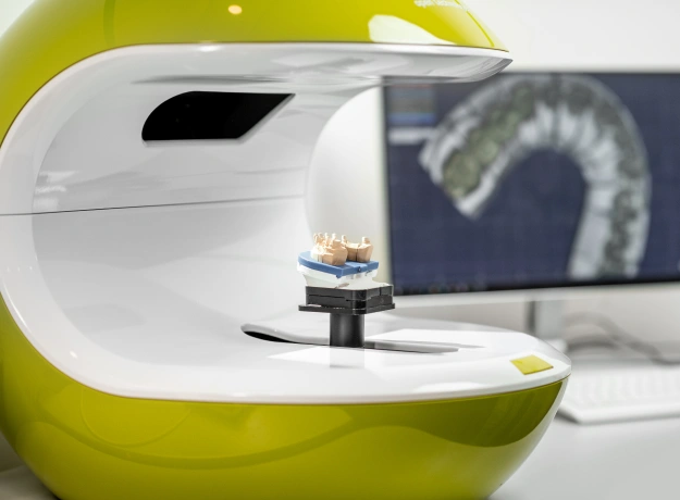 Advanced dental imaging equipment with monitor displaying scan results in modern dental office.