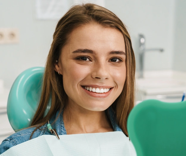 Young woman smiling in dental chair at Forest Hills Family Dentistry office.