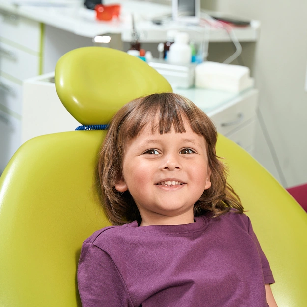 Young child smiling in dental chair at Forest Hills Family Dentistry office.